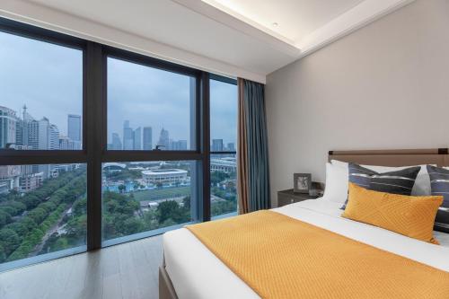 a bedroom with a bed and large windows at Star Residence ICC Guangzhou in Guangzhou