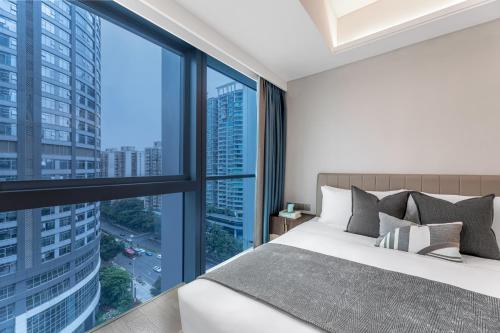 a bedroom with a bed and large windows at Star Residence ICC Guangzhou in Guangzhou