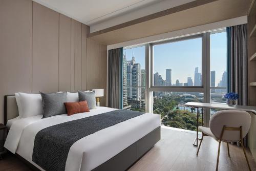 a bedroom with a large bed and a large window at Star Residence ICC Guangzhou in Guangzhou