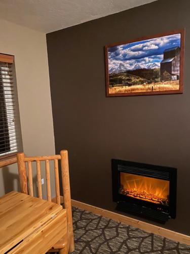 a living room with a fireplace with a picture on the wall at Teton Peaks Resort in Tetonia