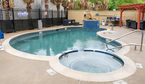 a hot tub in a swimming pool in a yard at Wingate by Wyndham Humble/Houston Intercontinental Airport in Humble