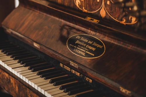 an old piano with a label on it at La Casa del General Hotel Boutique in Hidalgo del Parral