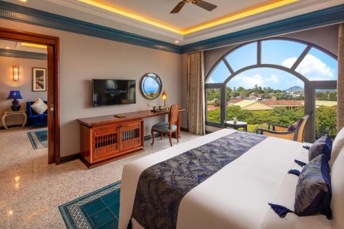a bedroom with a large bed and a large window at Silk Path Grand Hue Hotel in Hue