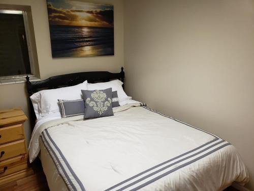 a bedroom with a bed with white sheets and pillows at The Orchard in South Jordan