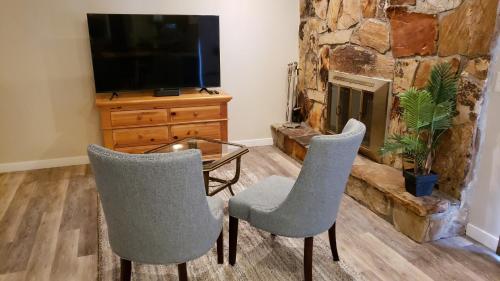 a living room with two chairs and a table and a fireplace at The Orchard in South Jordan