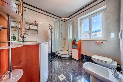 y baño con 2 lavabos, ducha y aseo. en Seafront Apartment Duo en Vis