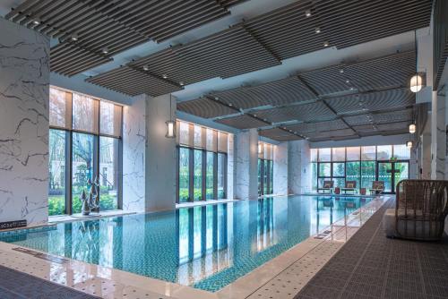 a large swimming pool with glass windows and a large pool at Holiday Inn Resort Maoshan Hot-Spring, an IHG Hotel in Jurong