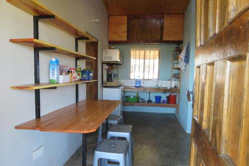 a kitchen with a wooden table in a room at Gateway Guest House in Monkey Bay
