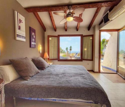 - une chambre avec un grand lit et un ventilateur de plafond dans l'établissement Apartamento Alba Beach, à Alicante