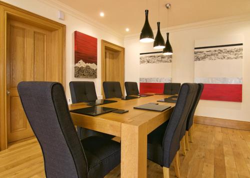 a conference room with a wooden table and black chairs at Escape Ordinary at Castle Hume in Enniskillen