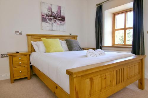 a bedroom with a large wooden bed and a window at Escape Ordinary at Castle Hume in Enniskillen