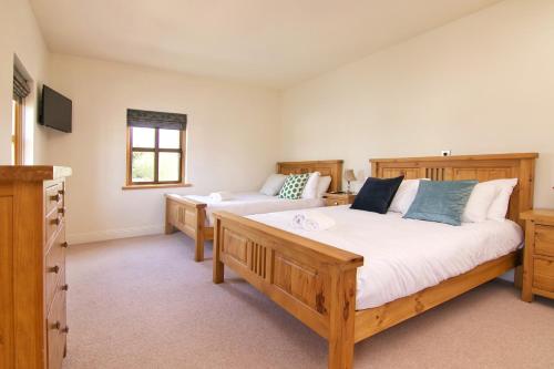 a large bedroom with two beds and a television at Escape Ordinary at Castle Hume in Enniskillen
