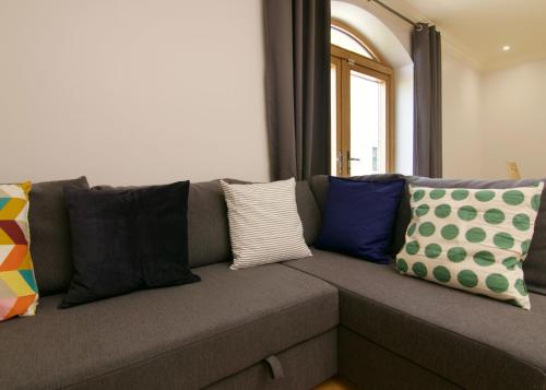 a gray couch with colorful pillows on it at Escape Ordinary at Castle Hume in Enniskillen