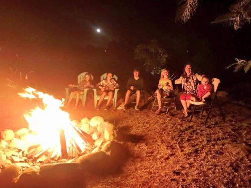 a group of people sitting around a fire at Finca Vidandrei CASA EUCALIPTO in Valle de Guadalupe