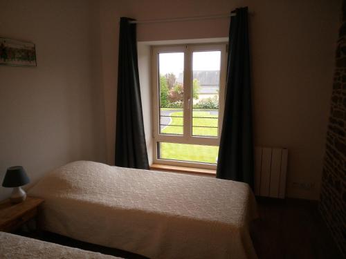 une chambre avec deux lits et une fenêtre dans l'établissement Gite de charme Les Buissonnets, à Plesder