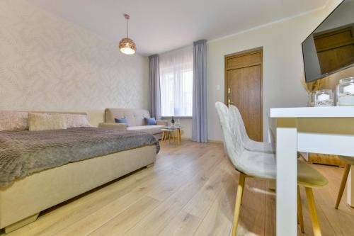a bedroom with a bed and a living room at Apartament u Ani 2 in Dźwirzyno