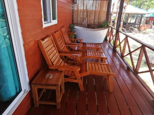 a porch with two chairs and a table at Koh Jum Delight Beach in Ko Jum