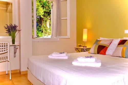 1 dormitorio con 1 cama con 2 toallas en Windward Suite @ Fiscardo waterfront, en Fiskardho