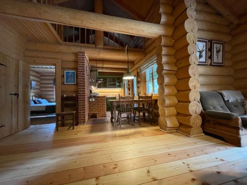 una sala de estar y comedor en una cabaña de madera en Kasepuu Holiday House en Uulu