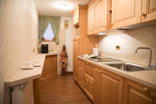 a kitchen with wooden cabinets and a sink at B&B Villa Cinzia Ledro in Ledro