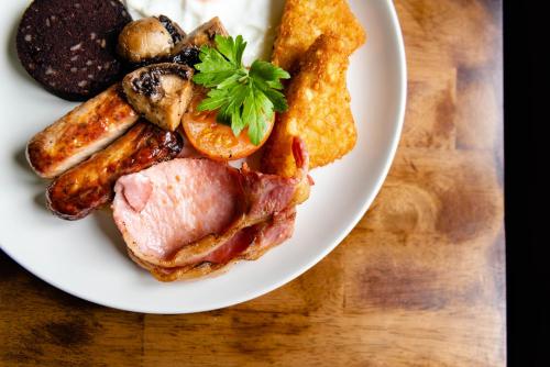 a plate of food with meat and vegetables on a table at The Old Manse Pickering in Pickering