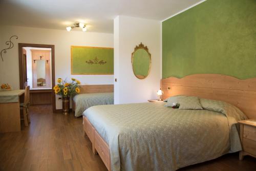 a bedroom with two beds and a sink and a mirror at B&B Villa Cinzia Ledro in Ledro