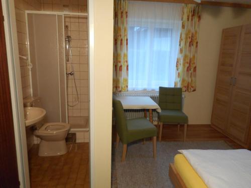 una camera da letto con bagno dotato di tavolo e lavandino di Haus Amalia a Strobl