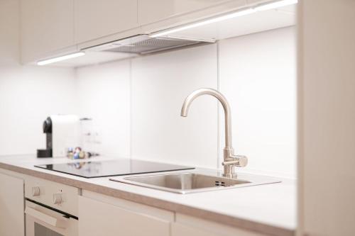 a kitchen with white cabinets and a sink at Apartment Congress Graz in Graz