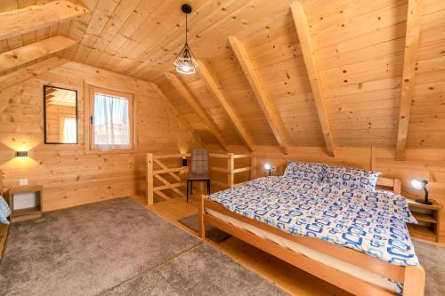 a bedroom with a bed in a log cabin at Green Top with jacuzzi in Žabljak