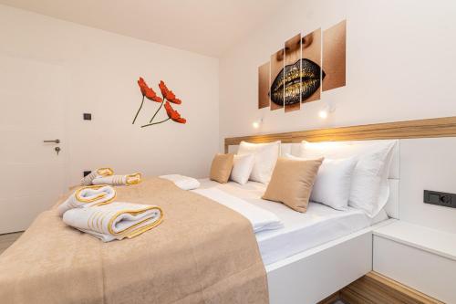 a bedroom with a large bed with towels on it at Villa Beganović in Krk
