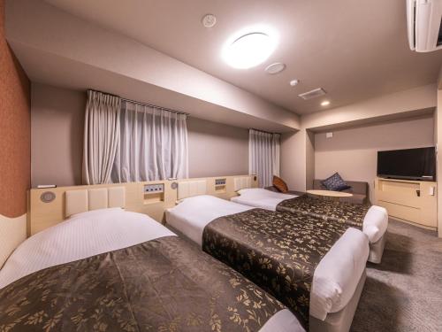 Postel nebo postele na pokoji v ubytování APA Hotel Shin Osaka Eki Tower