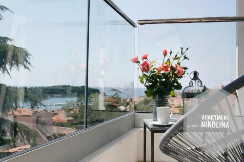een balkon met een vaas met bloemen op een tafel bij Apartments San Francesco in Rovinj