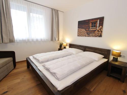 - une chambre avec un grand lit et des draps blancs dans l'établissement Comfy apartment with two bathrooms, in Neukirchen, à Neukirchen am Großvenediger