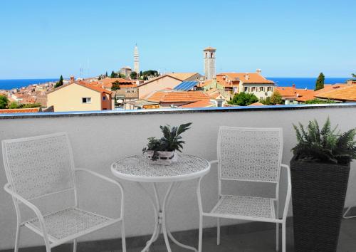 een tafel en 2 stoelen op een balkon met uitzicht bij Apartments San Francesco in Rovinj