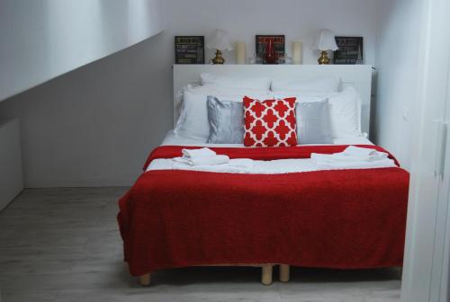 a bed with a red blanket and pillows on it at Tourist House Bologna - Self check-in in Bologna