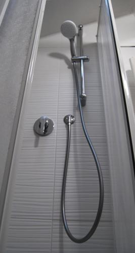 a shower with a hose attached to a mirror at Tourist House Bologna - Self check-in in Bologna