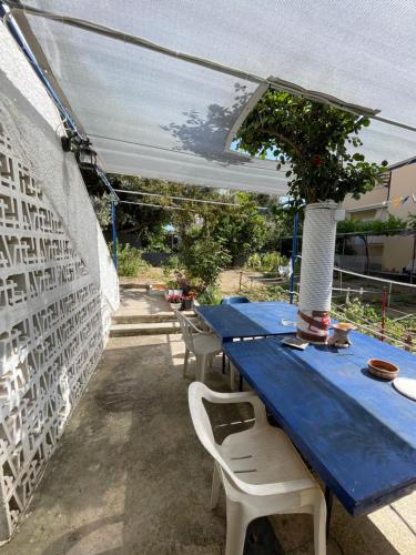 une table bleue avec des chaises et un vase sur elle dans l'établissement Penelope, à Vrontádos