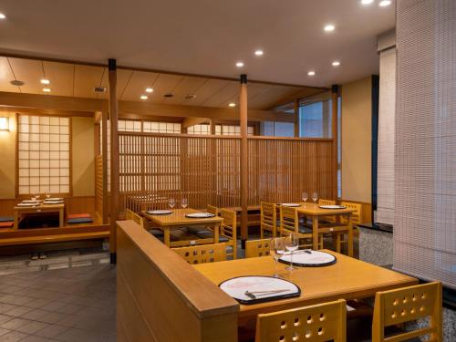 a restaurant with wooden tables and chairs in a room at ART HOTEL Miyazaki Sky Tower in Miyazaki