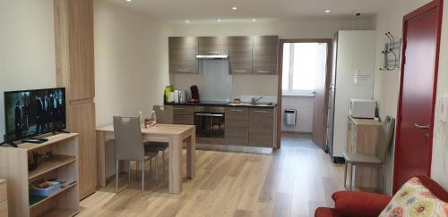 Il comprend une cuisine avec une table à manger et un salon. dans l'établissement Meublés du 25 N3 Studio 1er Etage, à Niederbronn-les-Bains