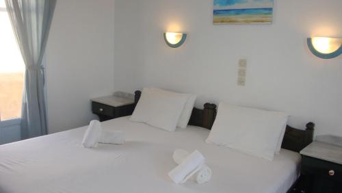 a bedroom with a bed with white sheets and pillows at Blue & Sea Studios Apartments in Drios