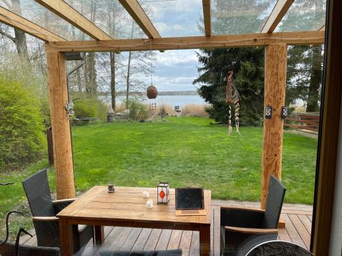 a wooden table on a deck with a view of a yard at Wandlitzsee in Wandlitz