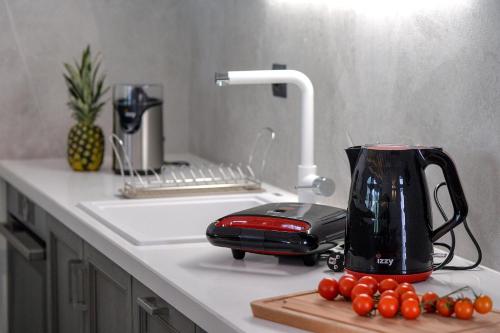 a kitchen counter with a toaster and tomatoes on a cutting board at Paxos Luxury Living Junior Suites in Gaios