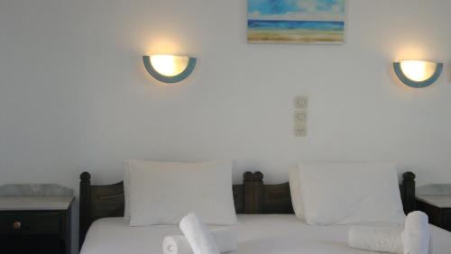 a bedroom with two beds and two lights on the wall at Blue & Sea Studios Apartments in Drios