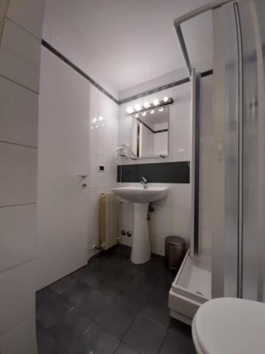 a white bathroom with a sink and a shower at Lerici Home in Lerici