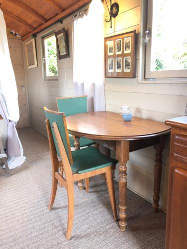 - une table et des chaises en bois dans la cuisine dans l'établissement Roulotte à Honfleur, à Honfleur