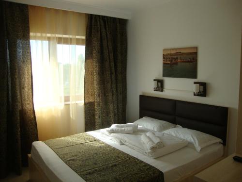 a bedroom with a bed with towels on it at Casa Lacul Sarat in Techirghiol