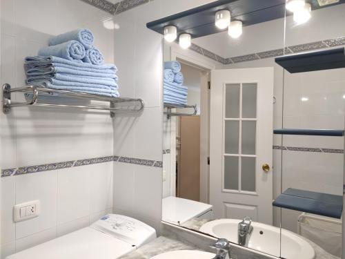 Un baño con lavabo, espejo y toallas. en Best location Playa Las Vistas. Los Cristianos. Wifi., en Los Cristianos
