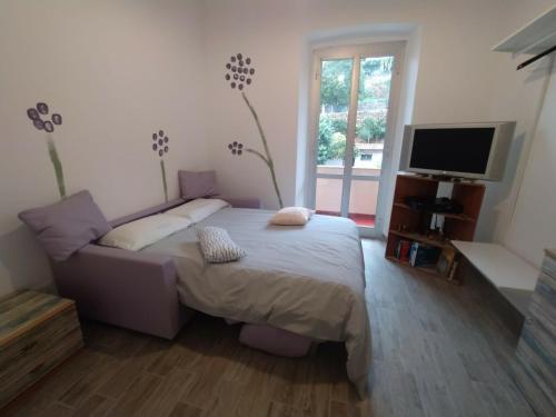 Schlafzimmer mit einem Bett und einem Flachbild-TV in der Unterkunft Appartamento Viola in Pietra Ligure