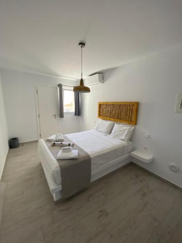 a bedroom with a large white bed with a wooden headboard at Chill Out Studio in Mýkonos City