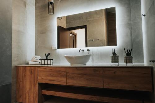 a bathroom with a sink and a mirror at Elia Luxury Suites in Plataria
